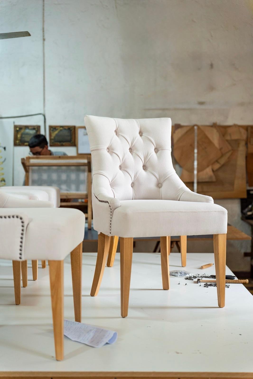 primer plano de un tapizado terminado en tela Aqua Clean sobre silla de comedor, detalle de la costura perimetral y el tensado de la tela, luz natural lateral